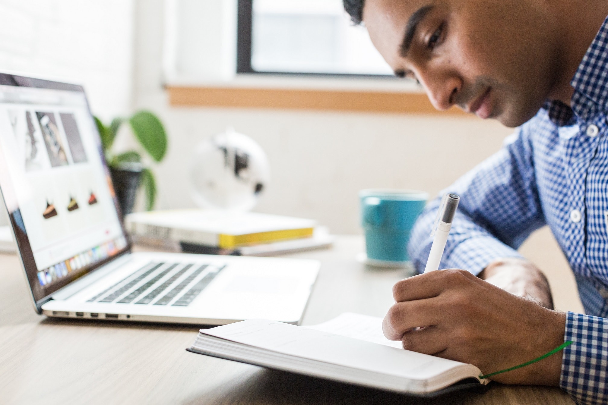 Man working from home with laptop and notebook