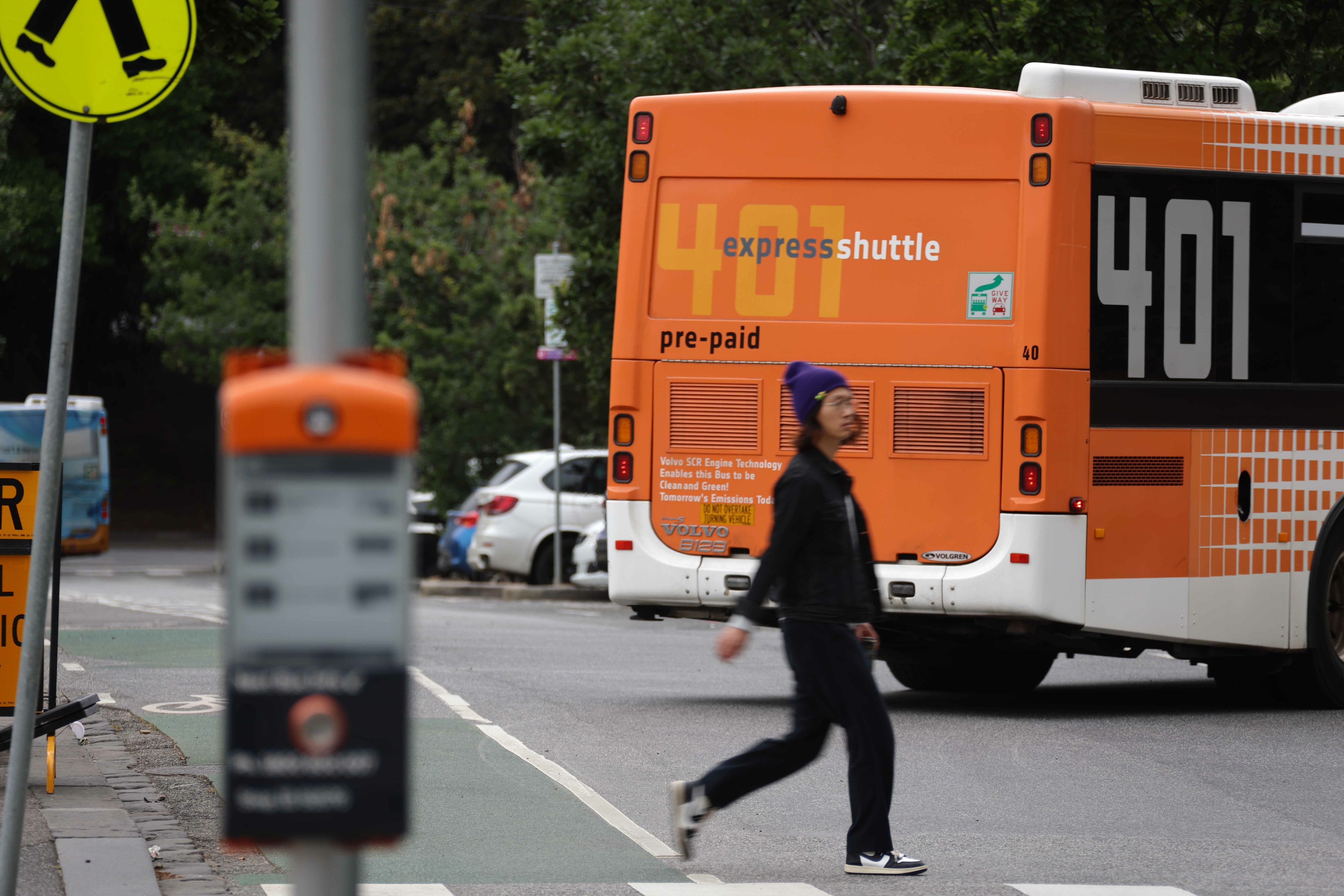 Bus with pedestrian crossing the road